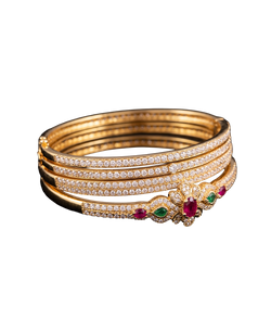 Gold-tone bangle set with brilliant stones and red and green gemstone accents