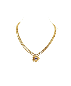 Gold-tone necklace with a floral pendant and contrasting center stone